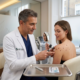 Close-up of a dermatologist examining a raised skin mole during a cryotherapy consultation, highlighting treatment options including freezing and minor surgical removal.